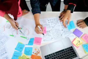 group of people writing on paper and sticky notes while planning engagement with community