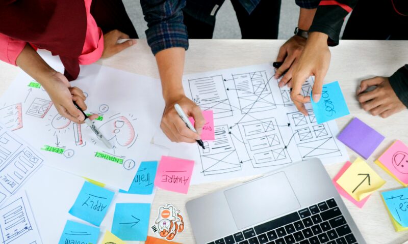 group of people writing on paper and sticky notes while planning engagement with community